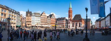 Frankfurt, Almanya 'daki Romerberg Meydanı' nda yarım keresteli binalar, merkezi bir çeşme, Eski St. Nicholas Kilisesi ve canlı sahnenin keyfini çıkaran insanlar yer alıyor..