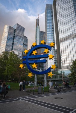 Frankfurt, Almanya 'daki Avrupa heykeli, gökdelenler, yeşillikler ve kaldırımlarla çevrili, bulutlu bir gökyüzü ve görünür kentsel faaliyet ile.