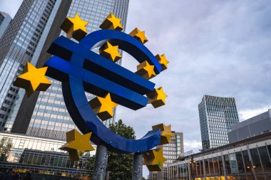 Sarı yıldızlı ikonik Avrupa heykeli, bulutlu bir gökyüzünün altında, modern gökdelenlerle çevrili Frankfurt, Almanya 'daki Avrupa Merkez Bankası yakınlarında duruyor..