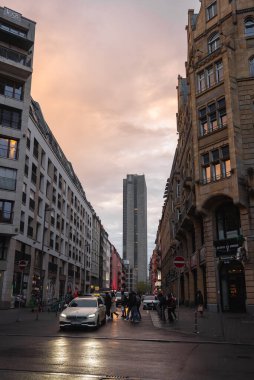 Alacakaranlıkta Frankfurt 'ta bir sokak. Gümüş Kule görünür, ıslak kaldırım akşam ışığını yansıtıyor. Modern ve tarihi mimarinin bir karışımı..