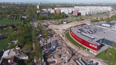 Riga, Letonya 'daki hava görüntülerinde ağır makineler, vinçler, işçiler ve Aleja etiketli kırmızı bir binanın yakınındaki yollarda kaydedilen ilerlemeler görülüyor..