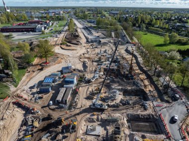 Riga 'da turna, kazıcı ve geçici tesisleri olan geniş bir inşaat alanı, açık bir gökyüzünün altında kentsel ve yeşil alanlar ile çevrili..