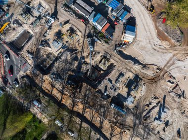 Riga, Letonya 'daki bir inşaat alanının hava görüntüsü vinçleri, kazıcıları, beton segmentleri, çelik takviyelerini ve trafiği olan yakınlardaki yolları gösteriyor..