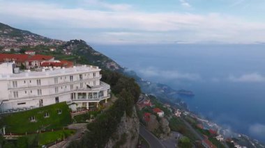 Amalfi kıyı şeridi üzerinde sorunsuz bir insansız hava aracı uçuşu. Uçurumlar, kıyı yolları, kırmızı çatılı binalar, lüks bir otel ve sakin Akdeniz suları..
