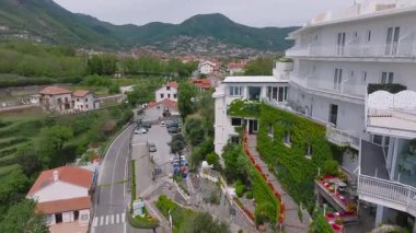 Sarmaşık kaplı duvarları, balkonları, yuvarlanan tepeleri, tuhaf bir kasabası, dolambaçlı yolu ve İtalya 'daki dağları çevreleyen lüks bir otelin pürüzsüz havası..