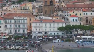 Amalfi Katedrali, renkli binalar, terracotta çatıları ve yavaş çekimle yemyeşil kayalıkların yer aldığı Amalfi, İtalya 'nın hava manzarası.