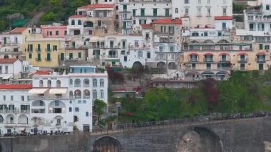 Amalfi kıyı şeridinde, lüks bir oteli, teraslı tepeleri, kırmızı kiremitli çatıları, dolambaçlı yolları ve İtalya 'daki dramatik uçurumları gösteren hava manzarası yayılıyor..