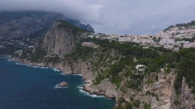 İtalya 'nın Capri kentinin havadan görünüşü, engebeli kayalıkları, turkuaz suları, yemyeşil alanları ve yamaçlara kurulmuş bembeyaz kasabaları gösteriyor..