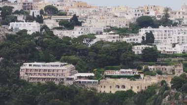 Capri, İtalya 'nın havadan görünüşü, pastel renkli binalar, bir kubbe yapısı, çam ağaçları ve yavaş hareket eden bahçeleri gösteriyor..