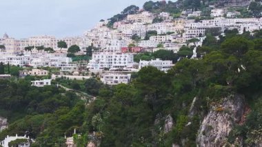 Capri, İtalya 'nın yavaş hava manzarası. Pastel binalar, yemyeşil alanlar ve dramatik sahil kayalıkları olan yamaçlar..
