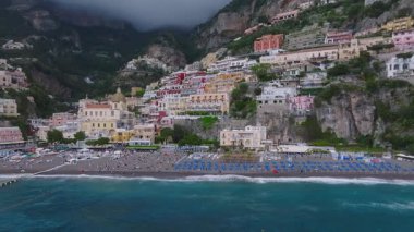 Positano 'nun İtalya' nın Amalfi Sahili 'ndeki hava manzarası renkli uçurum kenarlı binalar, kubbe şeklinde bir kilise ve turkuaz hareketli sular..