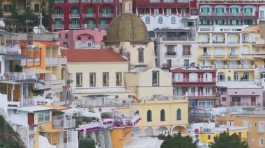 Amalfi Sahili 'ndeki Positano' nun havadan görünüşü, Santa Maria Assunta Kilisesi, renkli tepe binaları ve hareketli yemyeşil alanlar..