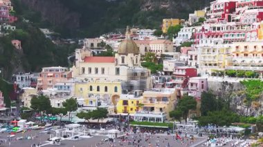 Amalfi Sahili 'ndeki Positano' nun havadan görünüşü, Santa Maria Assunta Kilisesi, renkli yamaç binaları, ve geniş kapsamlı hareketlerle yemyeşil.