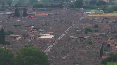 Pompei 'nin antik harabelerinin havadan görünüşü, taş yapılar, sokaklar ve İtalya' da ağaçlar ve bitki örtüsüyle çevrili bir amfi tiyatro..