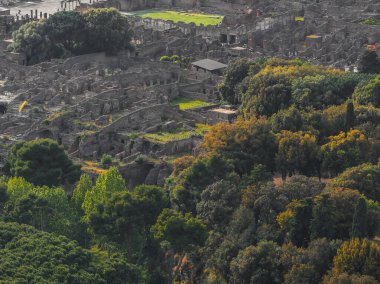 Pompei 'nin İtalya' daki antik harabelerinin havadan görünüşü, çevresindeki yemyeşil ve ağaçlarla taştan yapılar, yollar ve duvarlar sergileniyor..