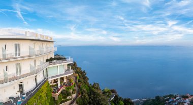 İtalya 'nın Amalfi kentindeki kayalık manzaralı lüks bir otelin balkonları, manzaralı bir terası, yemyeşil bir bahçesi ve Tyrhenian Denizi manzarası var..