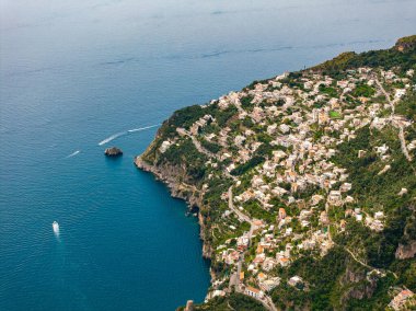 Uçurumlardaki beyaz ve pastel binaların, dolambaçlı yolların, yemyeşil çimlerin, kayalıkların ve Tyrhenian Denizi 'ndeki teknelerin yer aldığı Amalfi, İtalya' nın hava manzarası..