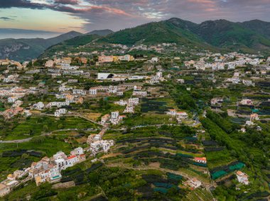 Ravello, İtalya 'nın havadan görünüşü, yamaç terasları, beyaz villalar, yemyeşil yemyeşil, ve yumuşak, bulutlu bir gökyüzünün altındaki dağlar..