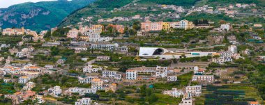 Teraslı manzaralar, renkli binalar, yeşil tepeler ve Oscar Niemeyer salonunun beyaz kıvrımlı çatısının yer aldığı Ravello, İtalya 'nın hava manzarası..