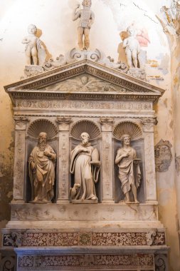 İtalya 'nın Amalfi kentinde mermer bir sunak ya da mezar, üç heykel, kabartmalı bir üçgen oyma, melek ve asker figürleri yer alıyor..