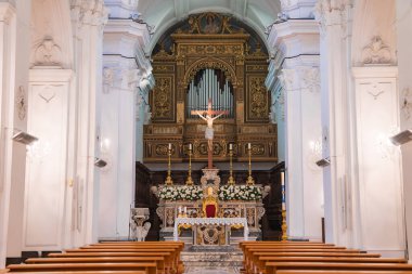 Entrika ile tasarlanmış sunak, haç, çiçek dekoru, altın organ, beyaz duvarlar, kemerli tavanlar ve bir Capri kilisesinde ahşap sıralar..