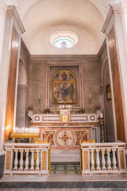 Altın aksanlı mermer sunak ve İtalya Capri 'deki bir kilisede merkezi dini bir tablo. Mum ve boyalı camlar dingin bir ortam ekler..