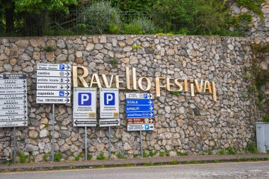 İtalya 'nın Ravello kentinde bulunan taş duvarda Piazza Duomo, Scala, Amalfi ve park alanlarına yönelik yönsel işaretlerin üzerinde' Ravello Festivali 'yazıyor..