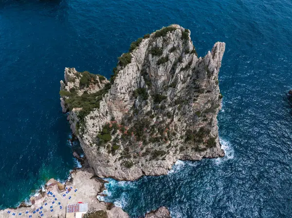 Çevresi Akdeniz sularıyla çevrili, tabanda sandalye ve şemsiyelerin yer aldığı küçük bir plaj alanı olan yüksek kayalık bir oluşum..