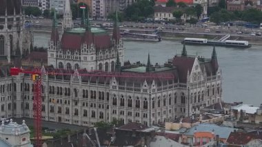 Budapeşte 'deki Macar Parlamento Binası' nın inşaat vinçleri, iskelesi, Tuna Nehri ve kademeli kamera tavasıyla hava manzarası..