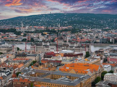 Macaristan 'ın Budapeşte kentinin havadan görünüşü, Tuna Nehri, Buda Tepeleri, Gellert Tepesi yakınlarındaki Macar Parlamentosu binası ve renkli bir günbatımı gökyüzü..