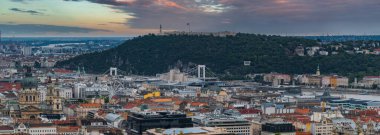 Budapeşte, Macaristan, Buda Kalesi Tepesi, Özgürlük Heykeli, Elisabeth Köprüsü, St. Stephen Bazilikası ve Tuna Nehri 'nin günbatımında yer aldığı hava manzarası.