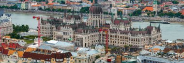 Macaristan 'ın Budapeşte kentindeki Macar Parlamento Binası' nın hava manzarasında Gotik Diriliş mimarisi, Tuna Nehri ve kentsel çevre yer alıyor..