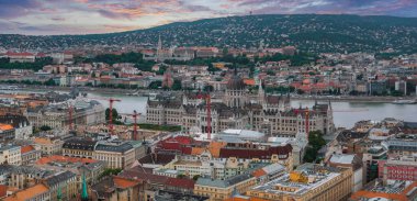 Macaristan 'ın Budapeşte kentinin havadan görünüşü, Tuna Nehri kıyısındaki Parlamento Binası, Balıkçı Kalesi, Matthias Kilisesi ve canlı bir günbatımı..