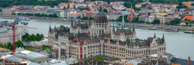 Macaristan 'ın Budapeşte kentindeki Macar Parlamento Binası' nın havadan görünüşü, Tuna Nehri 'ndeki tekneler, tarihi binalar ve sürmekte olan inşaatlar..