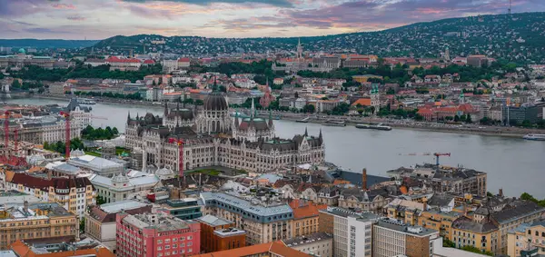Macaristan 'ın Budapeşte kentinin havadan görünüşü, Tuna Nehri yakınlarındaki Macar Parlamentosu binası, tarihi çatılar ve gün batımında Buda Tepeleri.