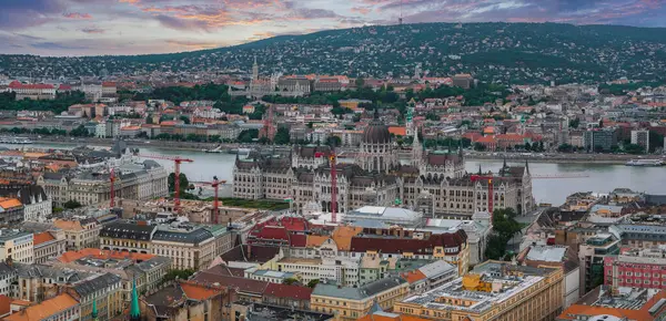 Macaristan 'ın Budapeşte kentinin havadan görünüşü, Tuna Nehri kıyısındaki Parlamento Binası, Balıkçı Kalesi, Matthias Kilisesi ve canlı bir günbatımı..