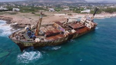 Kıbrıs Rum Kesimi 'nin kayalık kıyı şeridi yakınlarındaki Edro III enkazının hava manzarası. Kamera paslı gemiyi, mavi suları ve engebeli kıyı şeridini tarıyor..