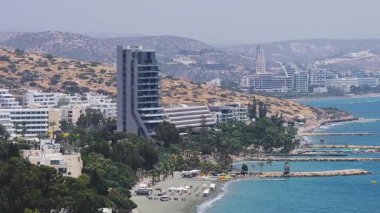 Kıbrıs Rum Kesimi, Limasol 'un hava manzarası, Akdeniz, dalgalar, tekneler, modern binalar ve açık güneş ışığı altında yuvarlanan tepeler.
