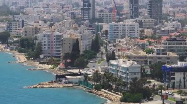Kıbrıs 'ın Limasol kentinin havadan görünüşü, turkuaz sular, modern binalar, palmiye ağaçları, kayalık çıkıntılar ve bir McDonald' s tabelası üzerinde dönüm noktası..
