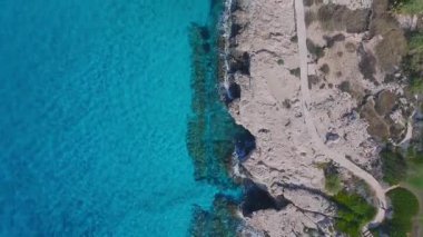 Kıbrıs Rum Kesimi 'nin Ayia Napa kentindeki hava görüntüleri, turkuaz suları, engebeli kayalık uçurumları, patikaları ve kıyı şeridi boyunca seyrek bitkileri gösteriyor..