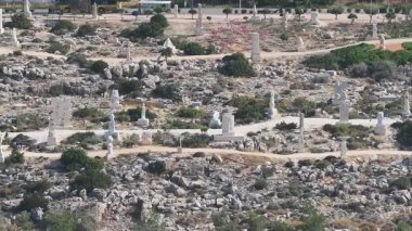 Kıbrıs 'taki Ayia Napa Heykel Parkı' nın hava görüntüsünde, beyaz taş heykeller, kayalık arazi ve arka planda yavaş çekim kamerasıyla deniz görülüyor..