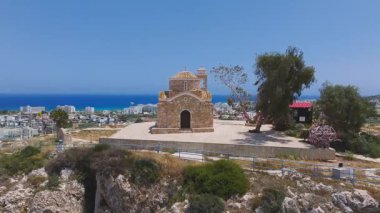 Kıbrıs Rum Kesimi 'nin Ayia Napa kentindeki St. Elias Kilisesi' nin hava manzarası, kademeli daire hareketi, taş mimarisi, yemyeşil ve Akdeniz 'i gösteriyor..