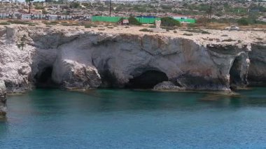 Doğal mağaraları, turkuaz suları, modern evleri, beyaz bir aracı ve Kıbrıs Rum Kesimi 'nin Ayia Napa kentindeki hafif su hareketleriyle engebeli kireçtaşı kayalıkları..