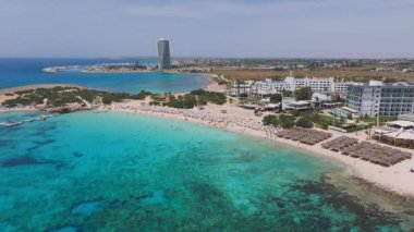 Kıbrıs Rum Kesimi 'nin Ayia Napa kentindeki Nissi Plajı' nda altın kumlar, turkuaz sular, güneşlik yataklar, şemsiyeler, renkli tekneler ve modern tatil beldeleri görülüyor..