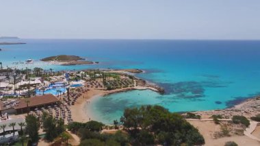 Kıbrıs Rum Kesimi 'nin Ayia Napa kentinin turkuaz suları, kayalık kıyı şeritleri, seyrek bitki örtüsü ve pürüzsüz hareketli dolambaçlı yürüyüş yollarını gösteren hava görüntüleri..