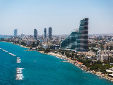 Kıbrıs 'ın Limasol kentinin havadan görünüşü modern yüksek binalar, kumlu plajlar, kayalık çıkıntılar ve Akdeniz' in berrak mavi sularını gözler önüne seriyor..