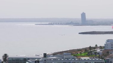 Kıbrıs Rum Kesimi, Ayia Napa 'nın hava görüntüsü, Akdeniz' i, kumlu plajları, kayalık çıkıntıları ve yavaş süpürme tavasıyla Faros Hotel 'i gösteriyor..
