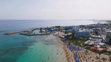 Kıbrıs Rum Kesimi 'nin Ayia Napa kentinin havadan görünüşü kumlu plajlar, tatil köyleri, yeşillikler ve Akdeniz' i gösteriyor..