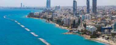 Kıbrıs 'ın Limasol kentinin havadan görünüşü, modern yüksek binalar, kıyı gezisi, dalgalar ve Akdeniz' in turkuaz sularını gösteriyor..