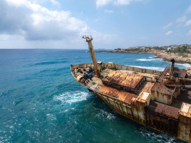 Edro III Batığı, paslanmış metal ve mavi Akdeniz sularına karşı eğimli bir direkle Kıbrıs kayalık kıyıları yakınında yer alıyor..